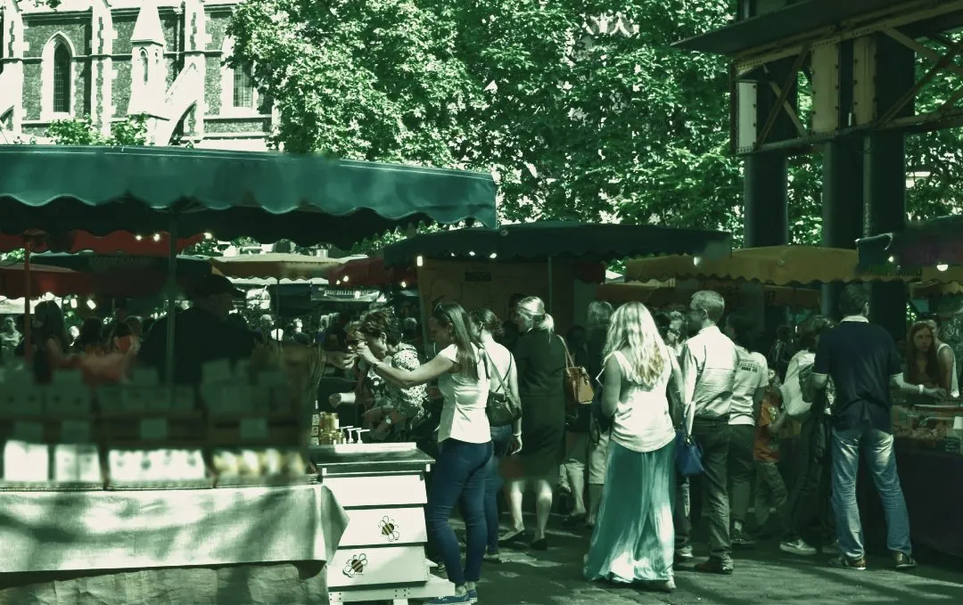 Marché animé, stands et promeneurs, en tons verts