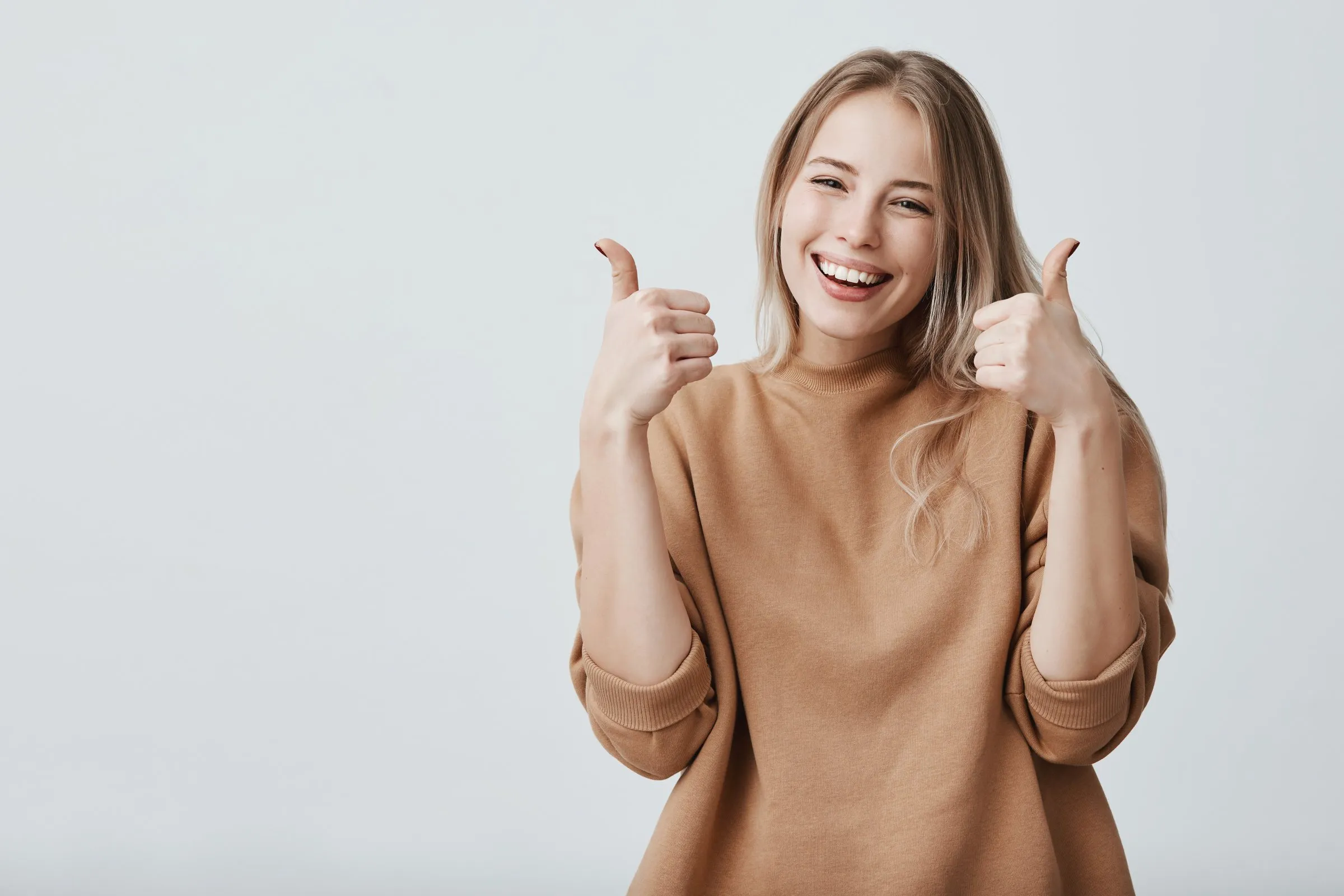 Cliente souriante, pouces levés, satisfaite de son passage en magasin