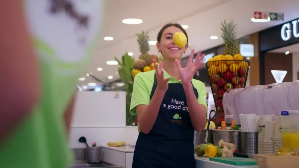 Une employée de Guapa Juice jongle avec des citrons derrière le comptoir du bar à jus