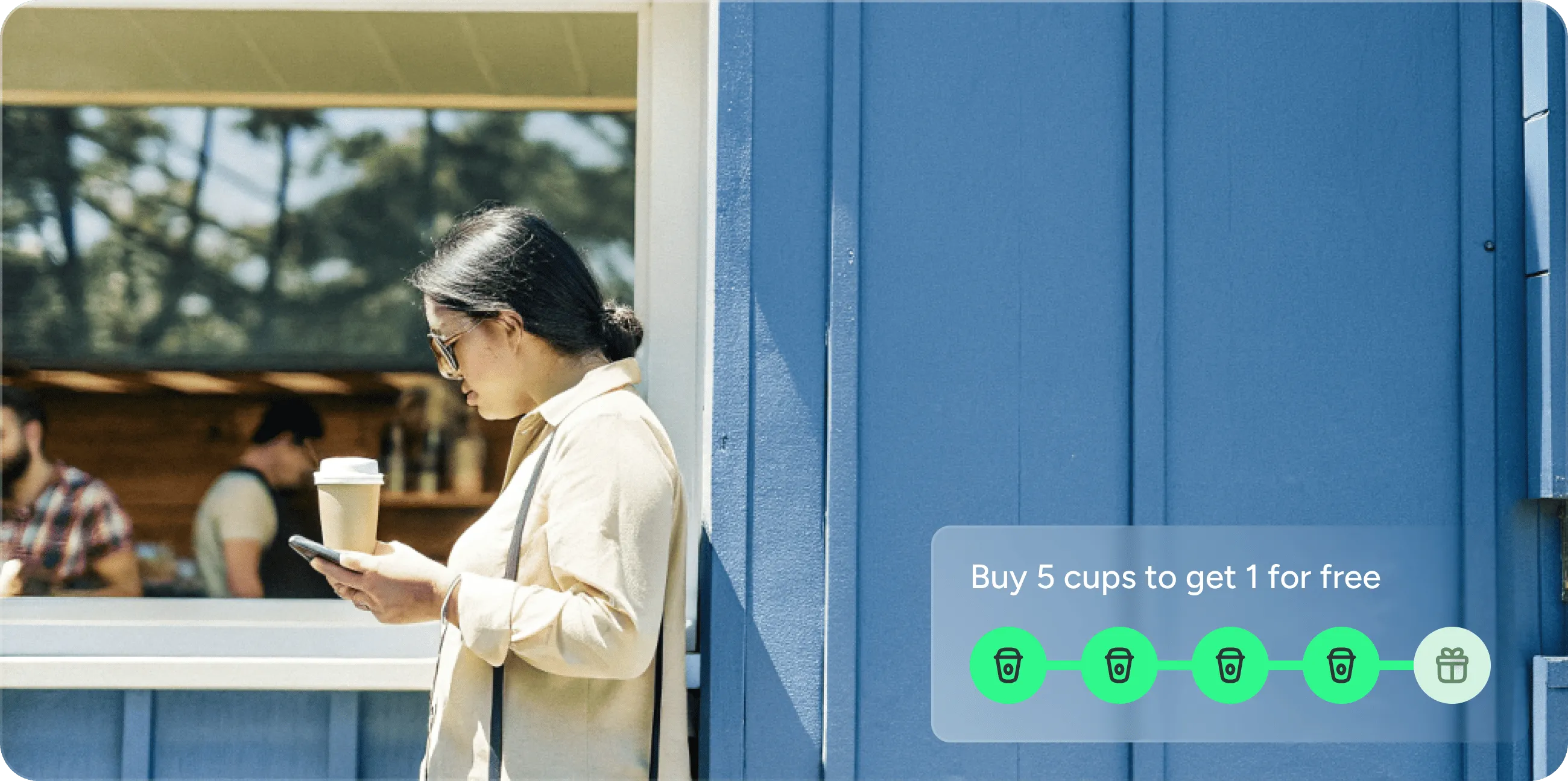 Une cliente devant un commerce de proximité, téléphone à la main.